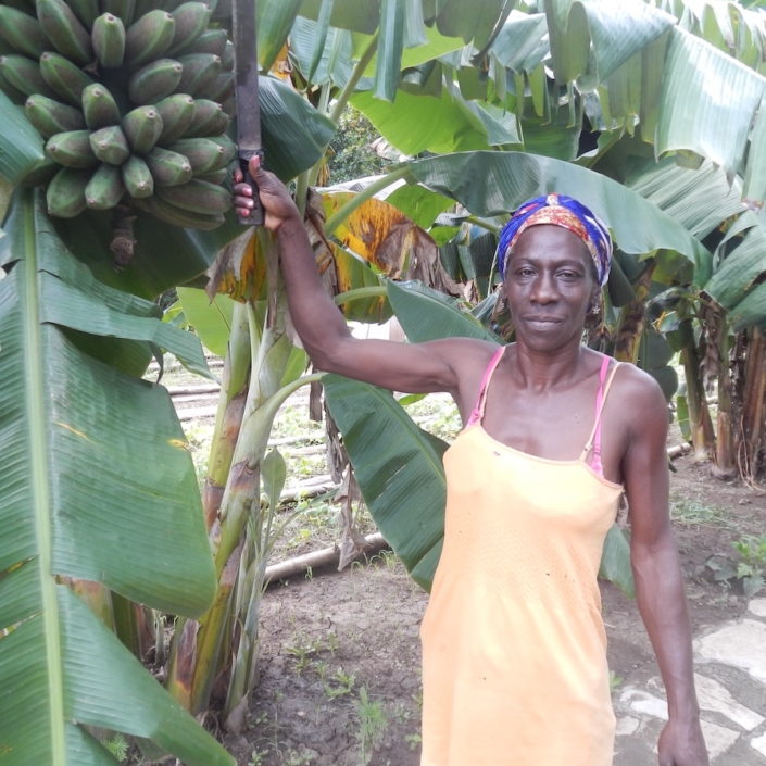 Maria with her machete cutting down some plantains